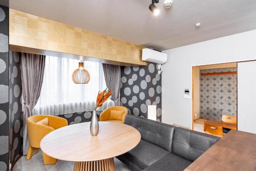 - un salon avec une table et un canapé dans l'établissement Bijou Suites Pine Brook 405, à Osaka