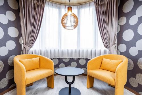 two chairs and a table in front of a window at Bijou Suites Pine Brook 405 in Osaka