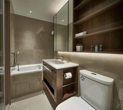 a bathroom with a toilet and a sink and a tub at Great World Serviced Apartments in Singapore