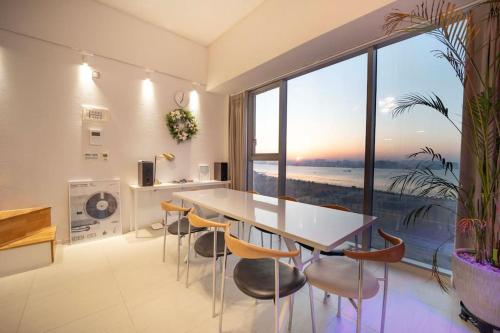 uma cozinha com mesa e cadeiras e uma grande janela em Sosodang 최고층 오션뷰 복층 호텔 em Incheon