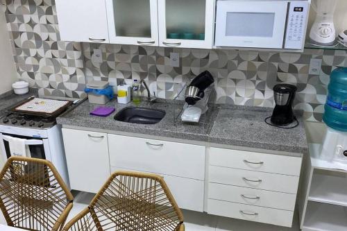 a kitchen counter with a sink and a microwave at Novo-aconchegante, moderno-lindo in Fortaleza