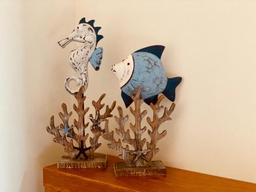 two figurines of fish on a shelf next to a wall at Oasis at Harbour lights Cairns in Cairns