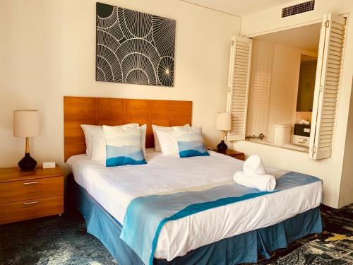 a bedroom with two beds with blue and white sheets at Oasis at Harbour lights Cairns in Cairns