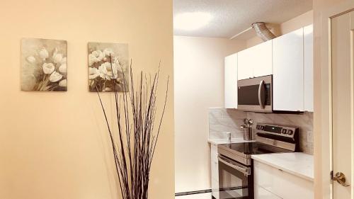 une cuisine avec une cuisinière et un micro-ondes dans l'établissement #304 Mountain View 1BR in Canmore DT, à Canmore