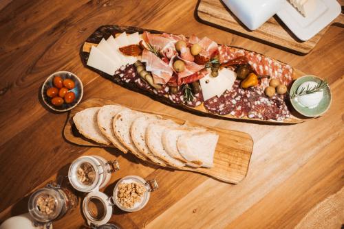 a wooden table with a plate of food and bread at VILA LISJAK - Apartments in Podčetrtek