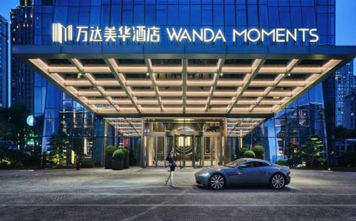 a woman standing in front of a building with a car at Ningbo Wanda Moments Hotel in Ningbo