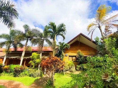a house with palm trees in front of it at Hortz Hotels And Resorts in Tagaytay