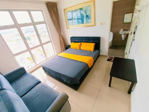 a bedroom with a bed and a blue couch at Kulai d'putra suites beside ioiMall near Airport and JPO in Kulai