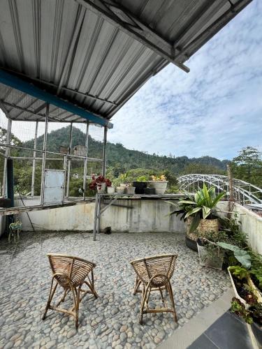 two chairs sitting on a patio with a roof at JAVA Hostel Tumpak Sewu in Sidomukti