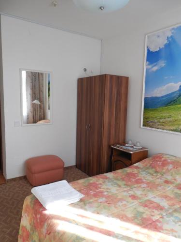 a hotel room with a bed and a dresser at Prezident in Dilove
