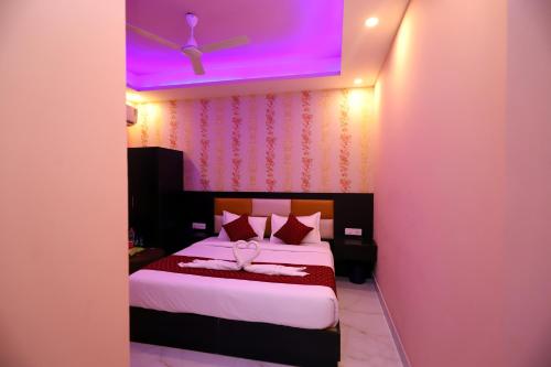 1 dormitorio con 1 cama con techo púrpura en Airport Hotel Peebles, en Nueva Delhi