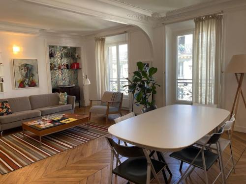 un salon avec une table et un canapé dans l'établissement Paris West LivingTrendy area spacious apt 2BR Opéra Montmartre, à Paris