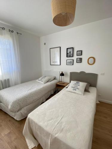deux lits dans une chambre aux murs blancs dans l'établissement Villa Oliera, à Saint-Florent