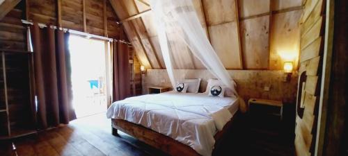 - une chambre avec un lit dans une pièce dotée d'une fenêtre dans l'établissement Girang Rinjani Bungalows, à Tetebatu