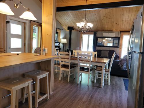 a kitchen and dining room with a table and chairs at Le Rassembleur in Saint Adolphe D'Howard