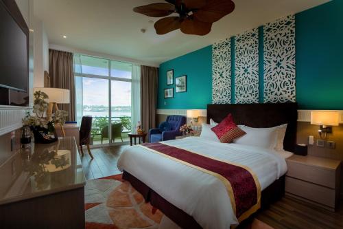 ハノイにあるThe Hanoi Club Hotel & Residencesの大きなベッドと大きな窓が備わるホテルルームです。