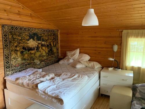 a bedroom with a bed and a painting on the wall at Luxury Holiday Home with Private Lake in Vehmaa