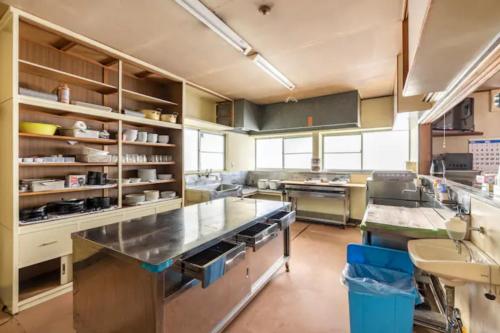 a large kitchen with stainless steel appliances in a kitchen at ザホテル湯沢オリエンタル in Yuzawa