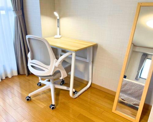 a desk with a chair and a lamp on it at The Global West in Niihama