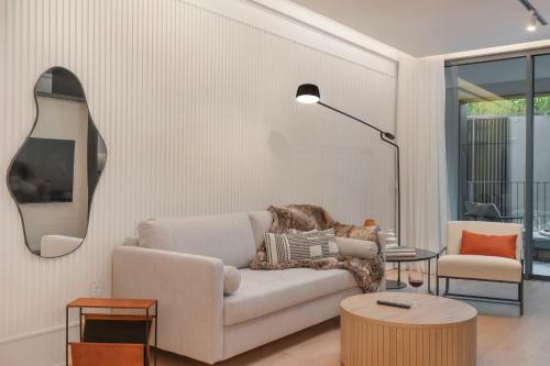 a living room with a couch and a mirror at Savoy Insular II by An Island Apart in Funchal