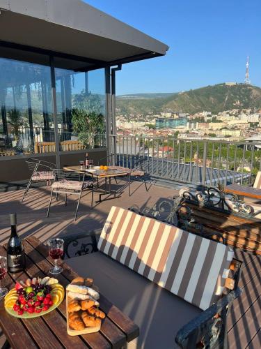 ein Tisch mit einem Teller Essen auf einem Balkon in der Unterkunft Hotel Livin in Tbilisi City