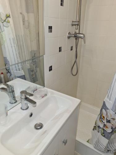y baño blanco con lavabo y ducha. en Studio- Antibes-Juan les Pins- Cote d'Azur, en Antibes