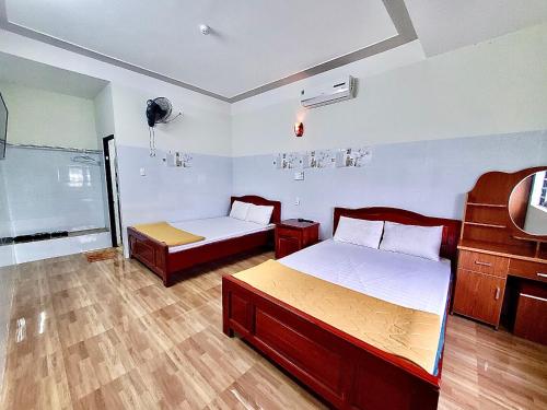 a bedroom with two beds and a tv in it at Nhà Nghỉ Thành Duy in Quang Ngai