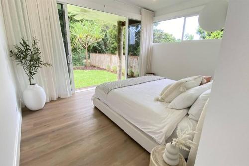 a bedroom with a large bed and a large window at Casa Tropico - Mission Beach in Mission Beach
