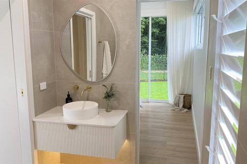 a bathroom with a white sink and a mirror at Casa Tropico - Mission Beach in Mission Beach