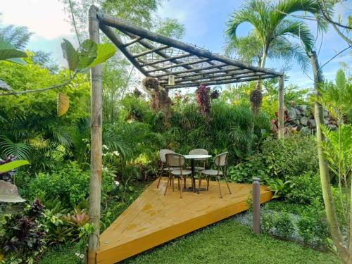 a wooden deck in a garden with a table and chairs at Hortz Hotels And Resorts in Tagaytay