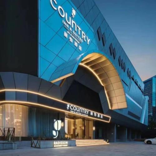 a building with a sign that reads country hotel at Country Inn & Suite by Radisson, Shanghai Railway Station in Shanghai