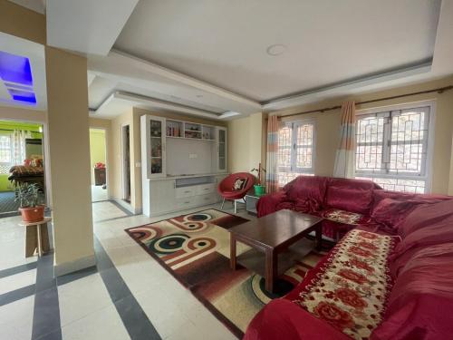 - un salon avec un canapé rouge et une table dans l'établissement Chovar homestay, à Kirtipur