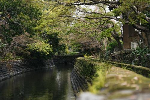 a small river with a stone wall next to a canal at Minamo in Ukiha