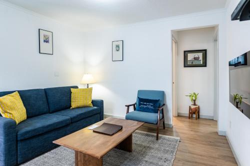a living room with a blue couch and a table at Inn at Haystack Rock in Cannon Beach