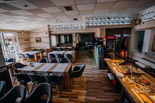 ein Restaurant mit Tischen und Stühlen in einem Zimmer in der Unterkunft Gros Hotel - Leskovac in Leskovac