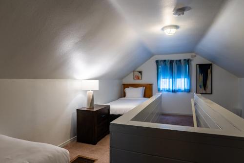 a attic room with two beds and a window at Inn at Haystack Rock in Cannon Beach