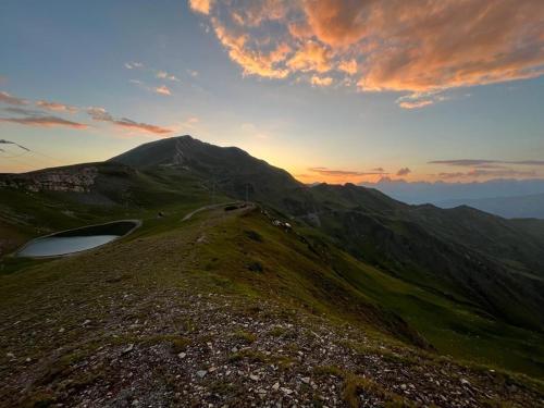 a view of a mountain with a sunset in the background at JorJ'Inn in Lentekhi