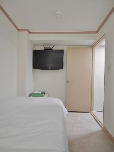 a room with a bed and a tv on the wall at J5 Hostel in Seoul