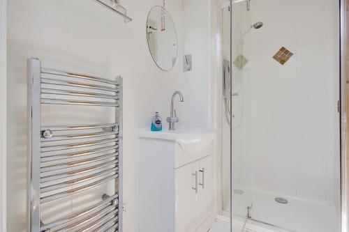 a white bathroom with a sink and a shower at Hilltop Farm in Sturminster Newton