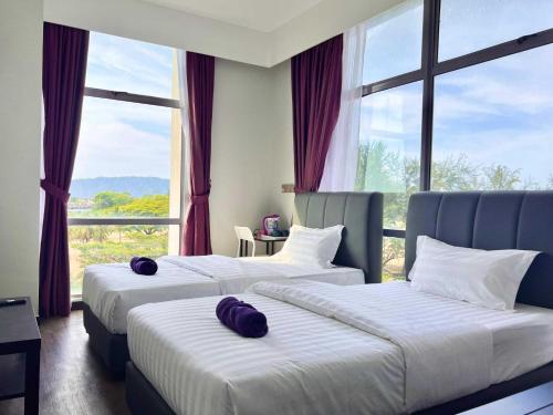 2 Betten in einem Hotelzimmer mit Fenstern in der Unterkunft Capital O 90985 Margo Hotel KK in Kota Kinabalu