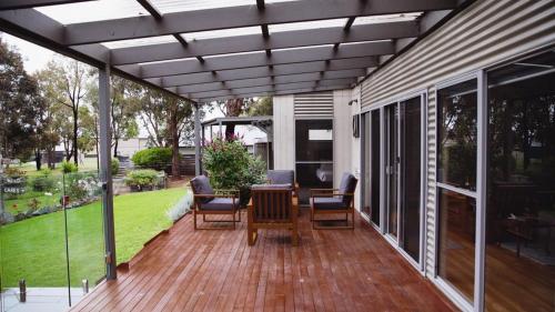 a patio with a table and chairs on a deck at Le Pelican - Metung Family Retreat in Metung