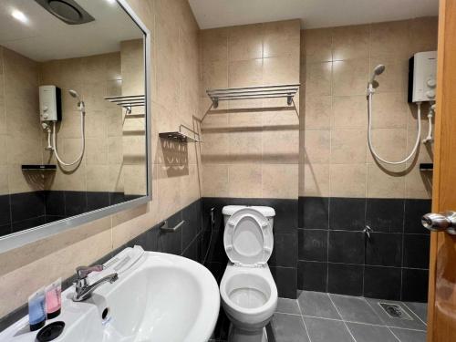 een badkamer met een wastafel, een toilet en een spiegel bij Capital O 90985 Margo Hotel KK in Kota Kinabalu