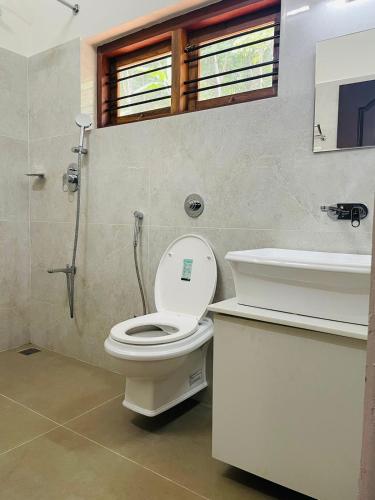 a bathroom with a toilet and a sink at Mountain View Villa Vacation Rental in Idukki