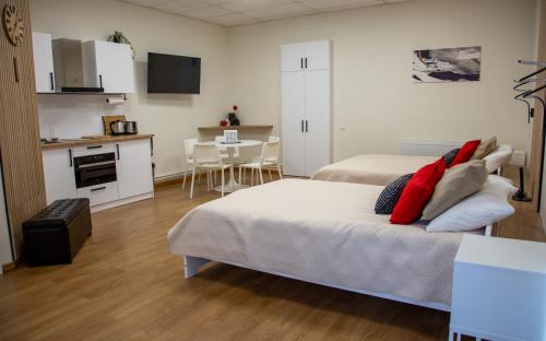 a bedroom with two beds and a kitchen with a table at ApartHotel Ritms in Krāslava