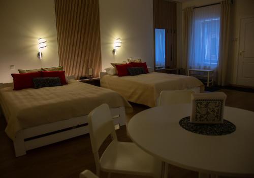 a hotel room with two beds and a table at ApartHotel Ritms in Krāslava
