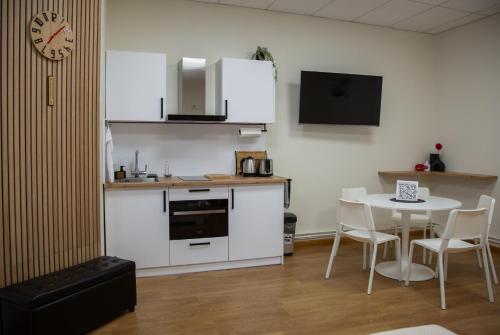 a kitchen with a table and a clock on the wall at ApartHotel Ritms in Krāslava