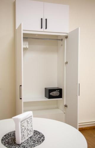 a white room with a chair and a cupboard at ApartHotel Ritms in Krāslava