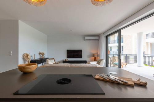 a living room with a kitchen with a table at Two Tides Luxury in Blue Bay