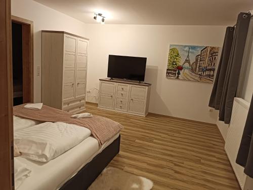 a bedroom with a bed and a flat screen tv at Edelsbacher Ferienwohnung in Edelsbach bei Feldbach