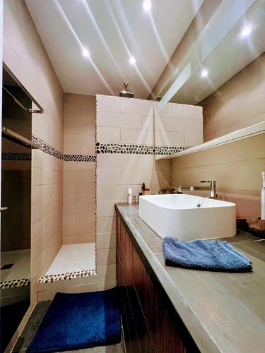 une salle de bain avec un lavabo blanc et une douche dans l'établissement Terrasse vue mer, Saint-Tropez, à Saint-Tropez